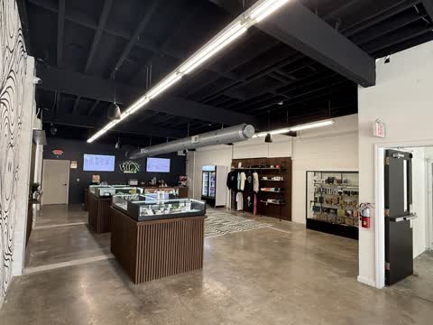 Main showroom at White Label Exotics with walnut display cases and an apparel wall.